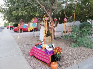 A low table holds a pink woven Bolivian polyester tablecloth, lanterns, silk floral garlands, and bowls of candy and glowsticks ready to light up when the sun goes down. 