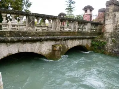 The blue green river LA Manoise flows between stone arches of a bridge in Orquevaux, France. Courtesy of French tourism websites. 